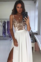 Abito lungo svasato bianco con spacco laterale e corpetto in tulle ricamato dorato, firmato Moda-Mania.
