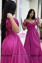 Abito lungo svasato da cerimonia fucsia Moda-Mania con scollo a barchetta e stringhe regolabili, dettaglio visibile in immagine.
