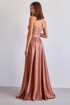 Abito lungo svasato dorato bronzo con spacco laterale e corpetto in tulle ricamato, firmato Moda-Mania.