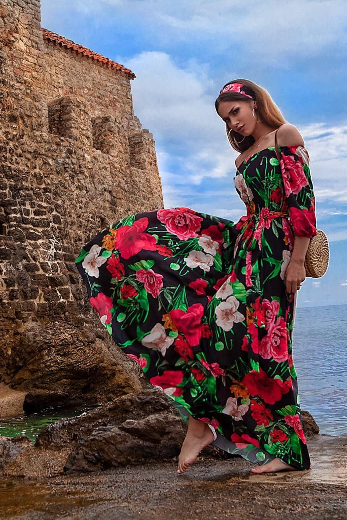 Abito lungo svasato estivo nero a fantasia floreale con scollo a barchetta in tessuto satinato, marca Moda-Mania.