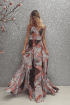 Abito lungo svasato moda-mania in velo multicolore viola con fantasia e stringhe posteriori regolabili, ideale per occasioni eleganti.