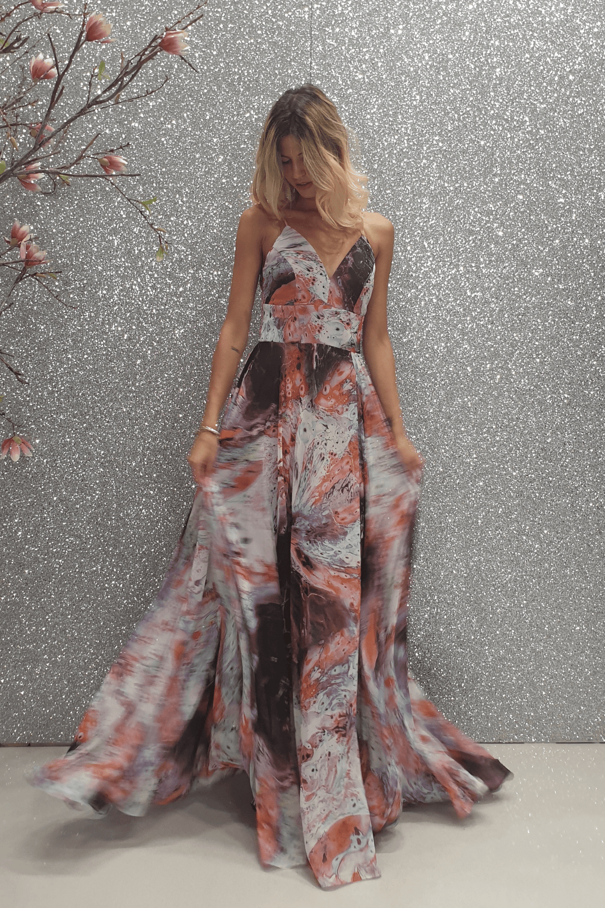 Abito lungo svasato moda-mania in velo multicolore viola con fantasia e stringhe posteriori regolabili, ideale per occasioni eleganti.
