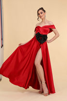 Abito lungo svasato rosso in taffetà con scollo a barchetta, spacco laterale e cintura con fiocco, modello nero.
