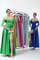 Abito lungo svasato turchese in taffetà con scollo a barchetta, spacco laterale e fiocchi decorativi, Moda-Mania.