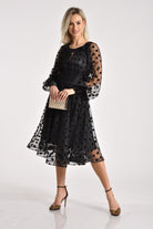 Abito midi nero svasato in tulle a pois con maniche lunghe e dettagli in velluto, firmato Moda-Mania.