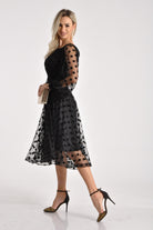 Abito midi nero svasato in tulle a pois con maniche lunghe e dettagli in velluto, firmato Moda-Mania.