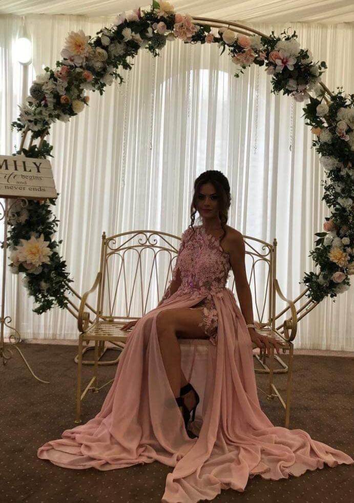 Abito lungo rosa con manica unica, strascico in georgette, corpetto a fiori 3D, marca Moda-Mania, immagine dettagliata e elegante.
