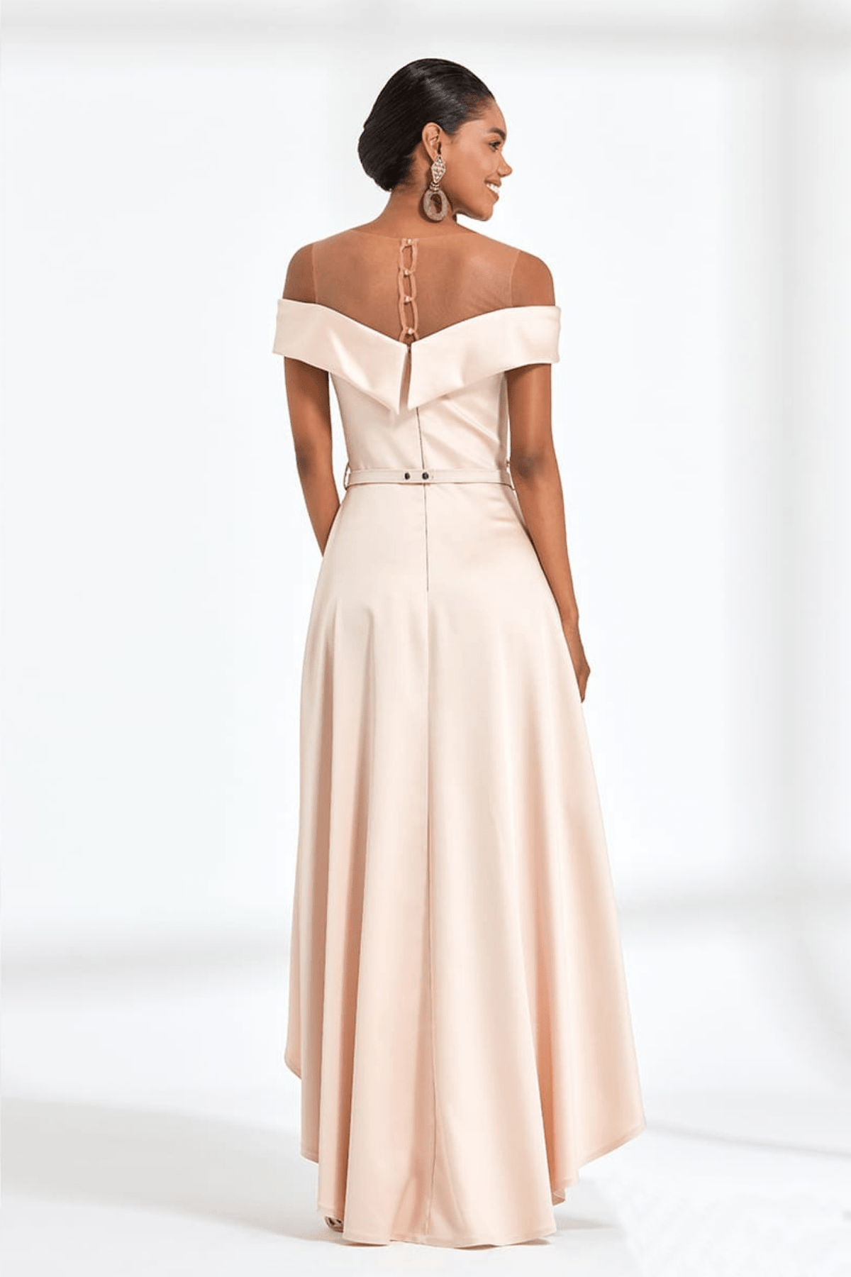 Abito nude Moda Mania con coda svasata, tessuto lucido e scollatura a barchetta, dettaglio dell'abito con coda elegante.