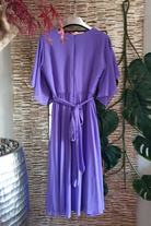 Abito lungo svasato per donne curvy in lavanda viola con maniche a campana e cinturino in vita con accessorio, firmato Moda Mania.