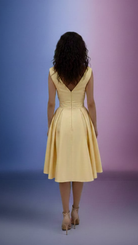 Abito svasato giallo midi Moda-Mania con corpetto floreale e dettagli di piume decorative, stile elegante e femminile.