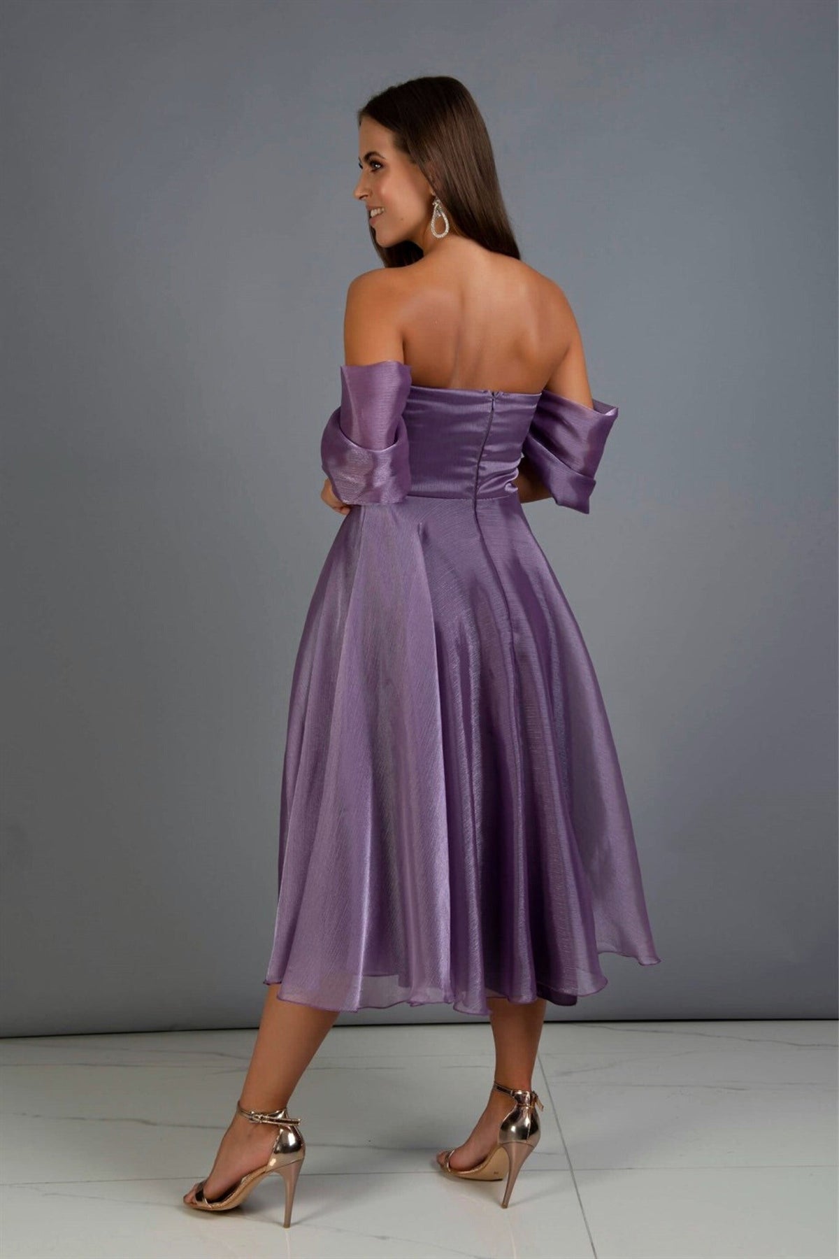 Abito lungo viola svasato in organza con scollo a cuore e maniche cadenti, di Moda-Mania, su modella che indossa l'abito.