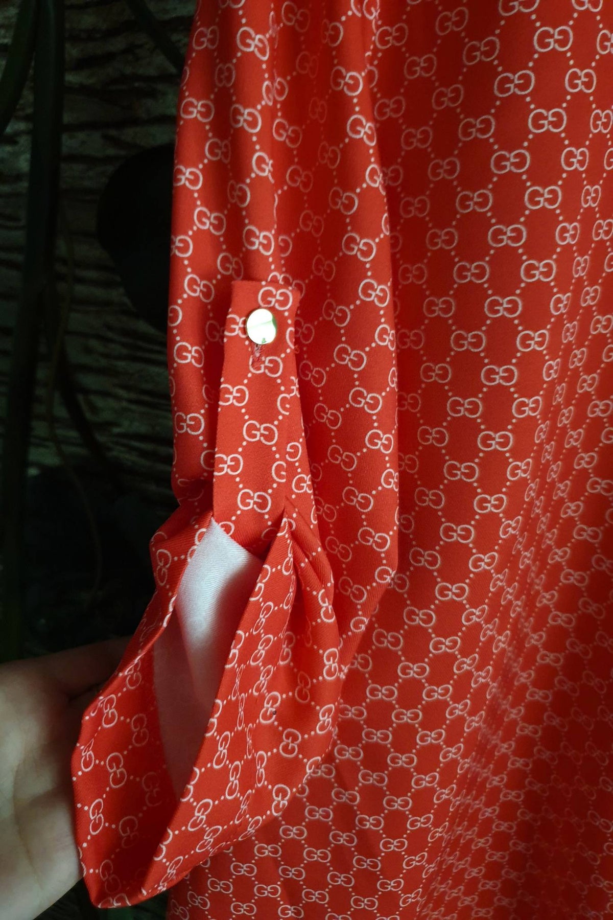 Blusa rossa corallo moda-mania con stampa G, scollo a V alla coreana e bottoni dorati, in tessuto leggero e elegante.