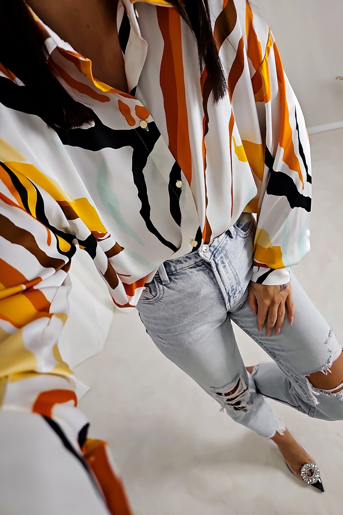 Camicia bianca larga Moda-Mania con fantasia astratta arancione, giallo e nero in tessuto satinato lucido con bottoni dorati