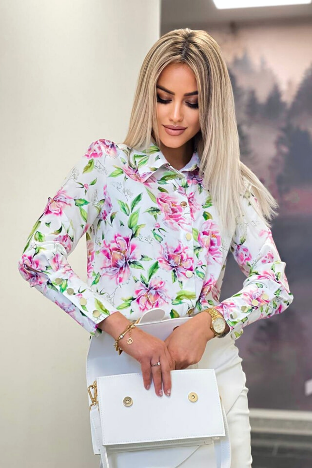 Camicia elegante bianca con fantasia floreale fucsia e foglie, bottoni dorati, marca Moda-Mania, vista frontale.