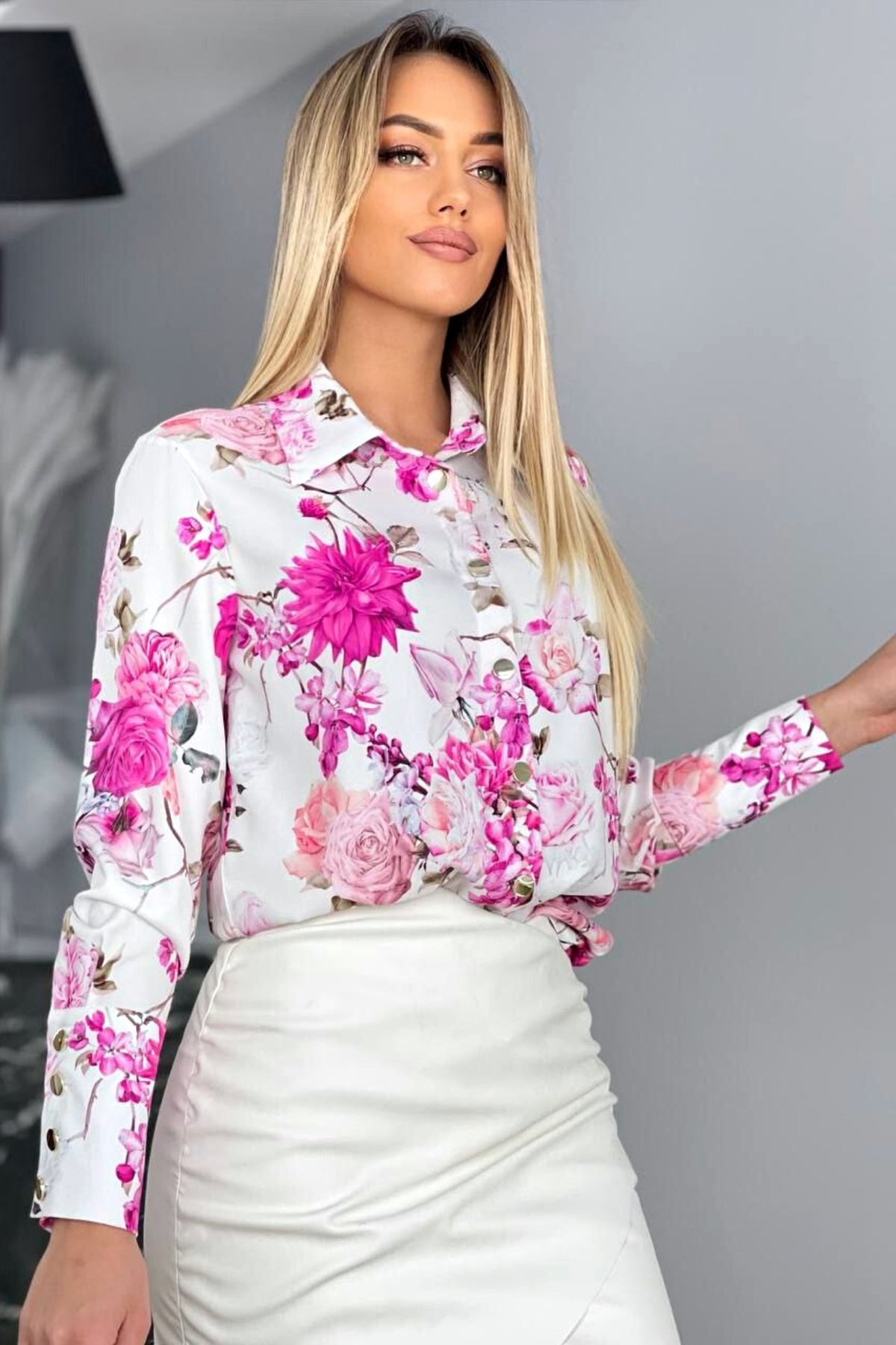 Camicia elegante bianca con fantasia floreale fucsia e bottoni dorati, modello Moda-Mania, tessuto leggero e stile raffinato.