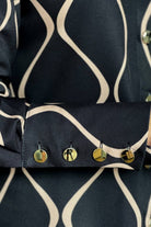 Camicia elegante nera con fantasia astratta beige, bottoni dorati, moda-mania, dettaglio colletto e maniche.