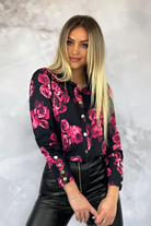 Camicia elegante nera Moda-Mania con fantasia floreale fucsia e magenta, bottoni dorati, tessuto leggero e dettagli raffinati