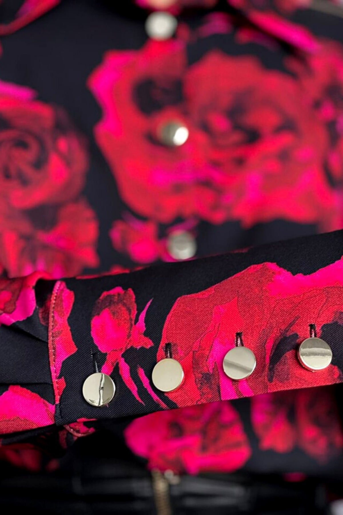 Camicia elegante nera Moda-Mania con fantasia di rose rosse e fucsia, bottoni dorati, tessuto morbido e dettagli raffinati.
