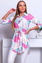 Camicia lunga bianca Moda-Mania con fantasia foglie, spacchi laterali e cinturino, tessuto leggero e stile elegante.