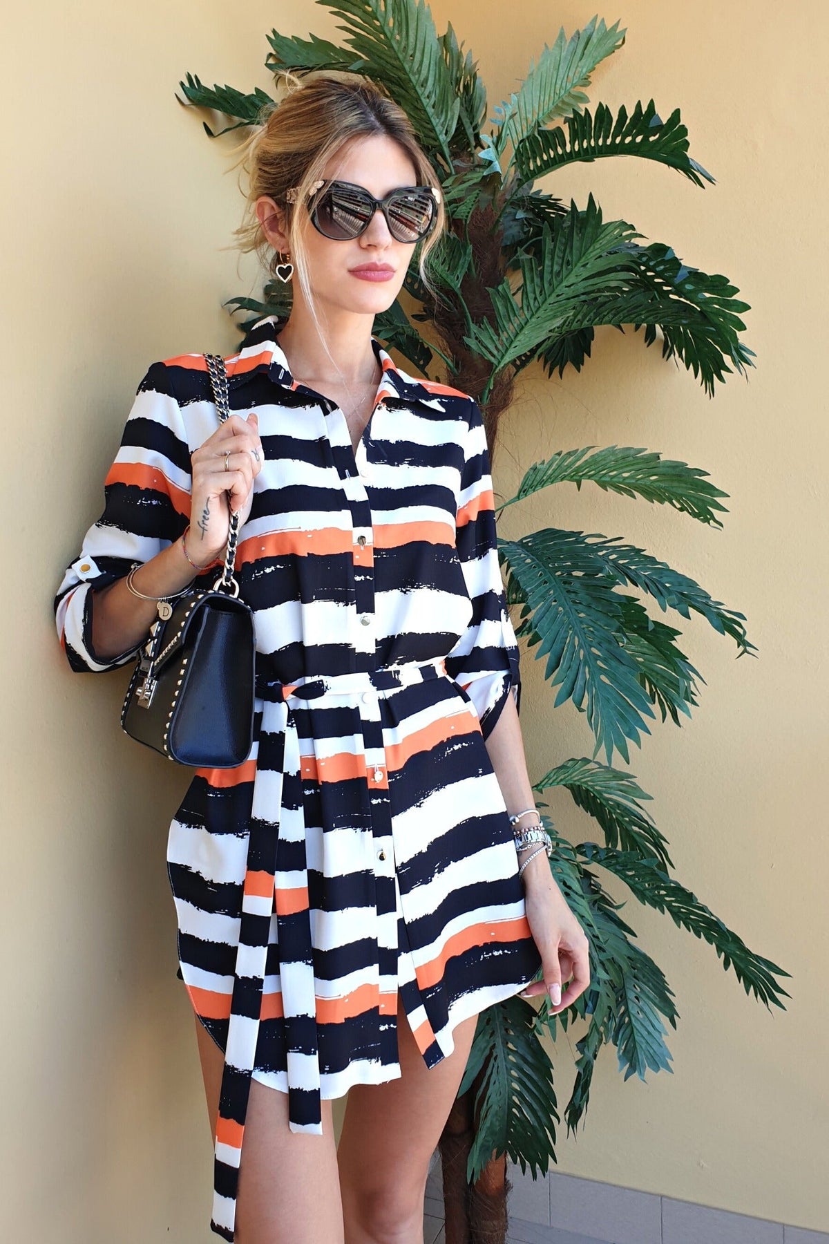 Camicia lunga bianca Moda-Mania con fantasia a righe nere e arancioni, spacchi laterali e cinturino, abiti corti elegante e casual.