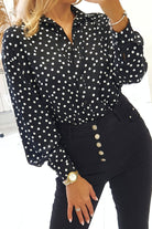 Camicia nera in viscosa con pois bianchi, accessoriata con fiore in tessuto, stile casual e femminile.