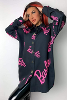 Camicia oversize nera Moda-Mania con scritta fucsia Barbie, bottoni a cuore dorati, stile casual e alla moda.