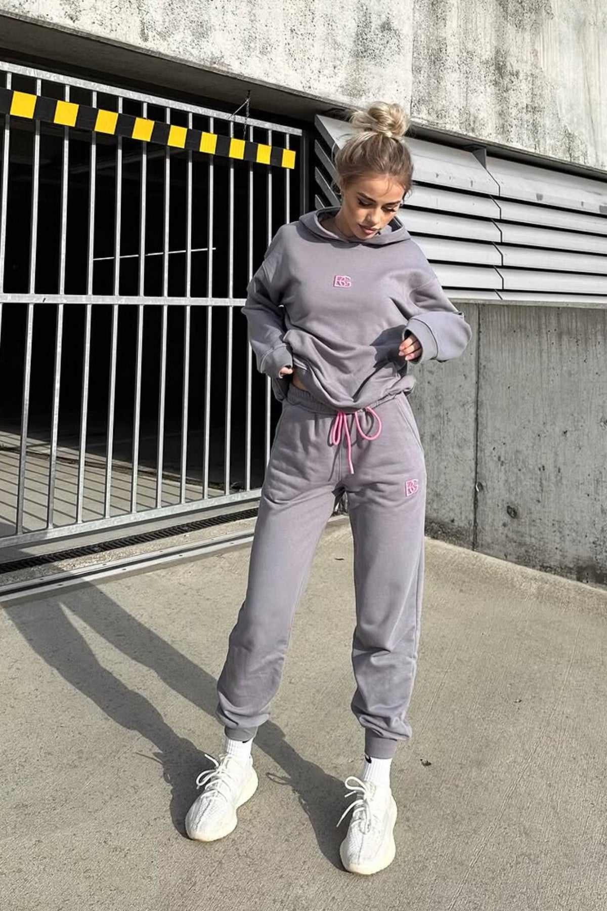 Completo tuta sportivo in cotone grigio con laccetti e logo fucsia, abbigliamento sportivo Moda-Mania, vista frontale.