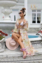 Abito corto Moda-Mania a fantasia floreale con maniche lunghe aperte e polsini a volants, perfetto per l'estate.