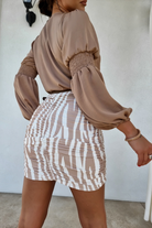 Minigonna corta a vita alta aderente fantasia zebrata bianco beige con arricciature, marca Moda-Mania, in tessuto elasticizzato.