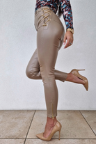 Pantaloni in similpelle lucida beige a vita alta Moda-Mania con catenella metallica e cerniere decorative alle caviglie.
