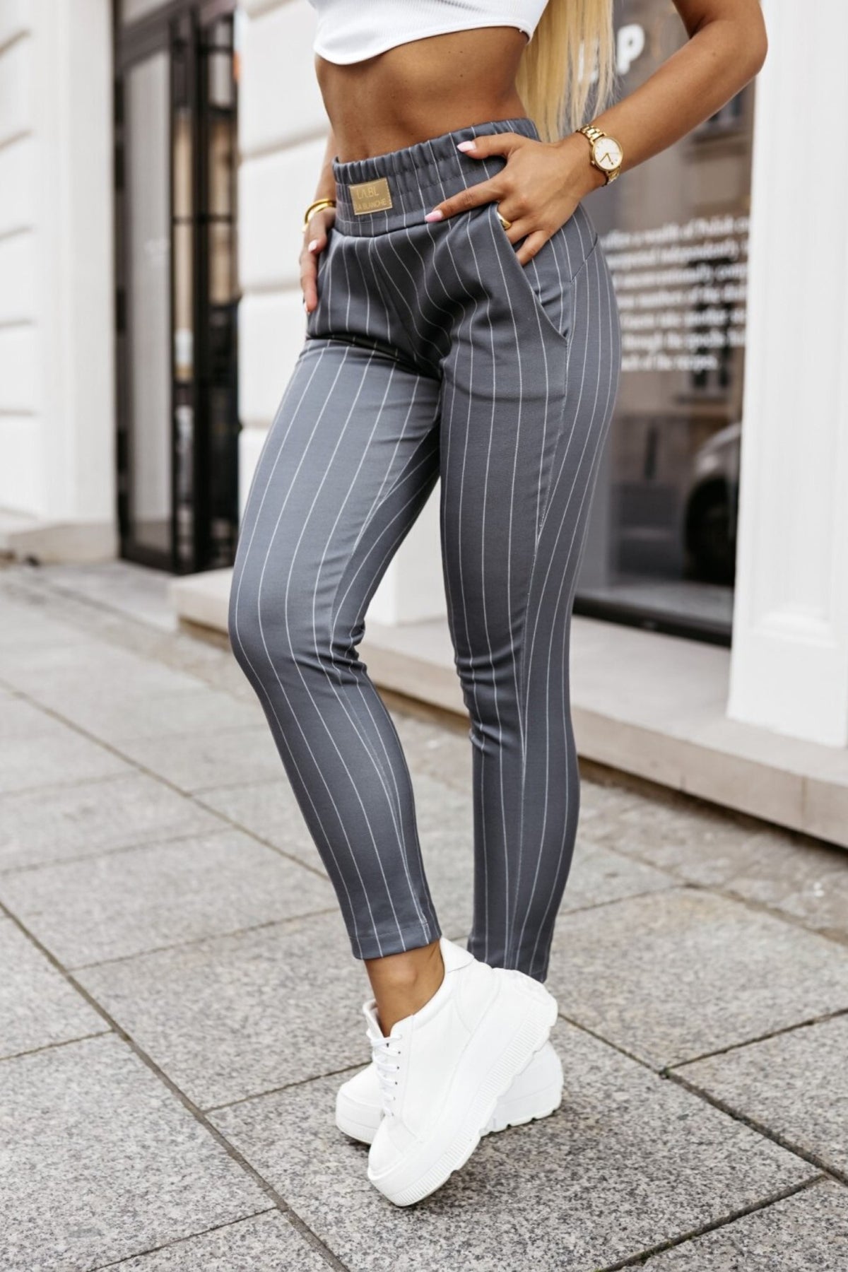 Pantaloni casual grigi a fantasia gessata con tasche laterali, marca Moda-Mania, in tessuto morbido e comodo.