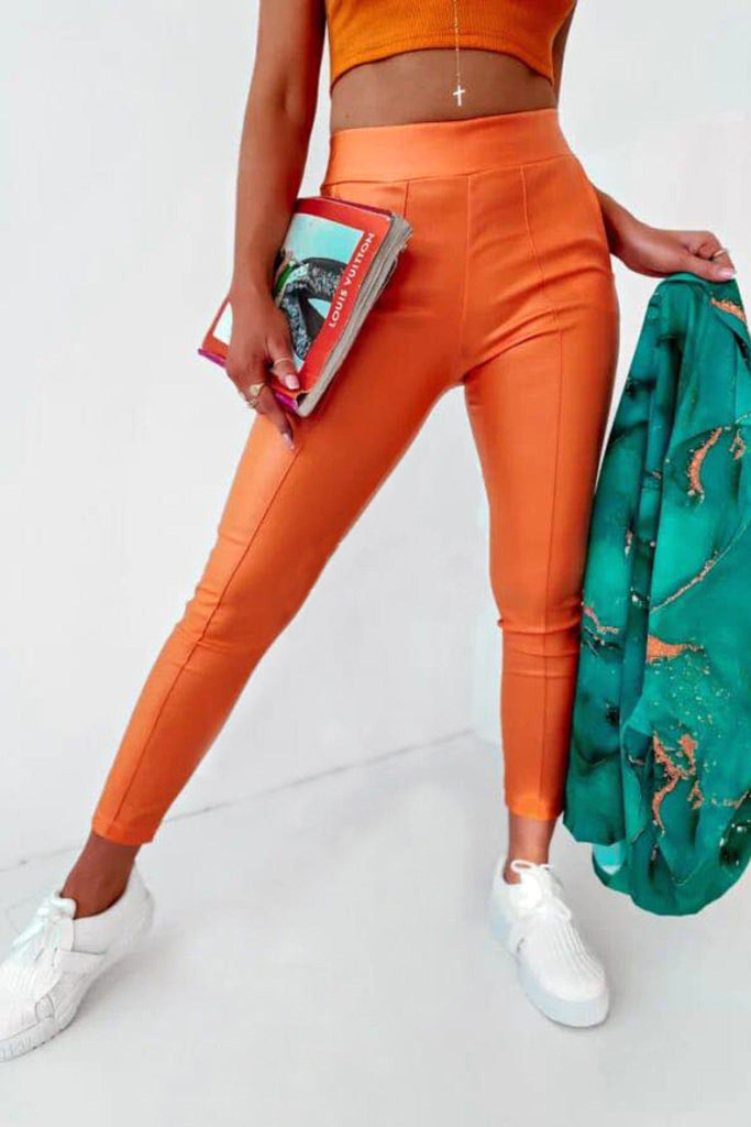 Pantaloni colore arancione in tessuto simile ecopelle a vita alta elasticizzata e tasche laterali