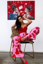 Pantaloni lunghi a palazzo rosa Moda-Mania con fantasia di rose rosse, tasche laterali e vita medio alta, tessuto leggero