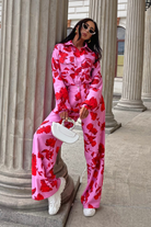 Pantaloni lunghi a palazzo rosa con fantasia di rose rosse, tasche laterali e vita medio alta, brand Moda-Mania.