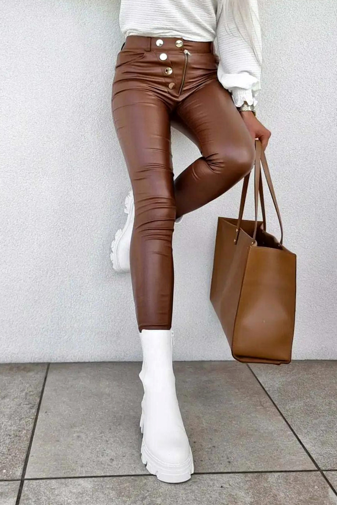 Pantaloni marrone bronzo in similpelle a vita alta accessoriati con bottoni e cerniere