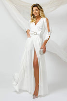 Abito lungo bianco Pretty Girl con spacco, maniche con aperture e fiocco con strass in vita, elegante e femminile.