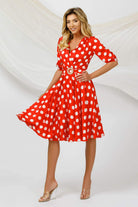 Abito corto rosso a fantasia pois bianchi, scollo a V e cintura, marca Pretty Girl, vestibilità svasata.