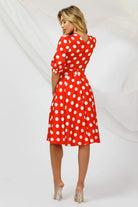 Abito corto svasato rosso a fantasia pois bianchi con scollo a V e cintura, marca Pretty Girl, dettaglio elegante e femminile.