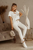 T-shirt bianco in cotone Moda Mania con stampa busto ragazza, cerchi beige e maniche corte con risvolto.