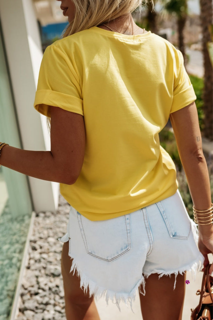 T-shirt giallo in cotone elasticizzato con stampa a piccoli fiori lilla viola sul davanti e manche corte con risvolto