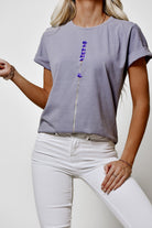T-shirt grigia Moda Mania in cotone elasticizzato con stampa di piccoli fiori lilla e viola, maniche corte con risvolto.