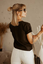Maglietta nera in cotone Moda Mania con stampa bianca di ragazza, maniche corte con risvolto, immagine frontale.