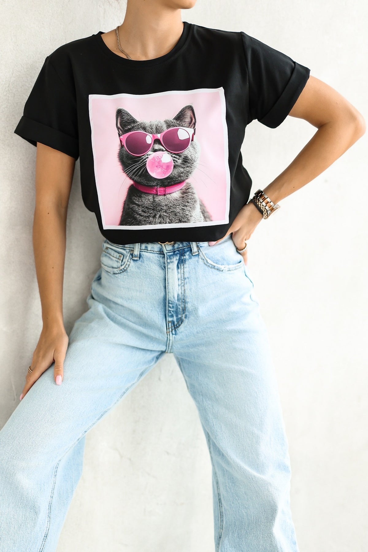 Maglietta nera in cotone elasticizzato con stampa gatto sul davanti e maniche corte con risvolto, di Moda Mania.