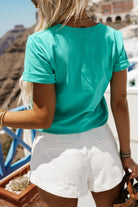 T-shirt verde acqua in cotone elasticizzato con stampa floreale rosa, maniche corte con risvolto, marca Moda Mania.