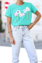T-shirt verde acqua in cotone elasticizzato con stampa floreale rosa, maniche corte con risvolto, marca Moda Mania.
