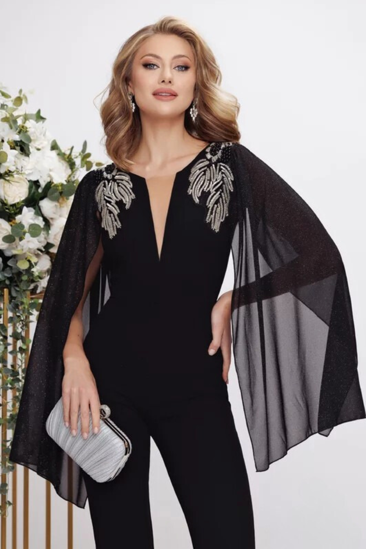 Salopette elegante nera Fofy, aderente ed elasticizzata con maniche aperte e dettagli argento sulle spalle.