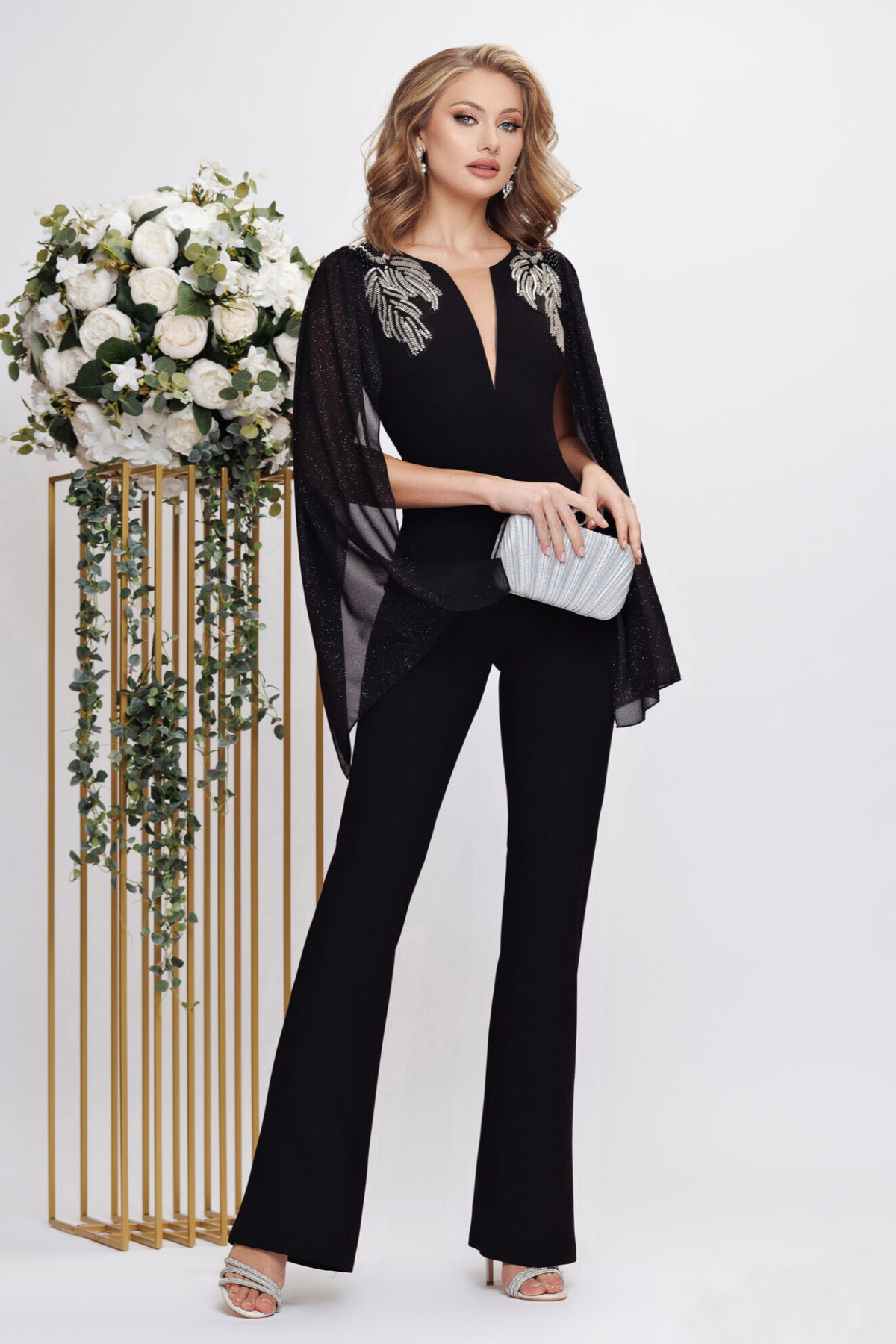 Salopette elegante nera Fofy, aderente, elasticizzata con maniche aperte e dettagli argento sulle spalle.