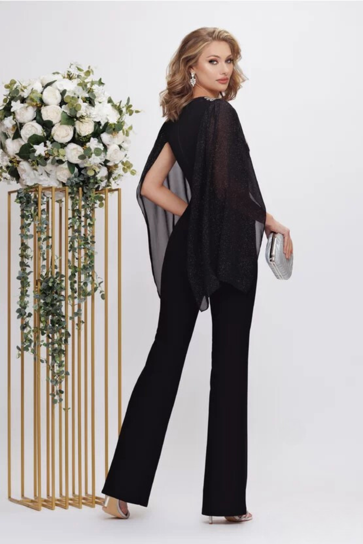 Salopette elegante nera Fofy, aderente ed elasticizzata, con maniche aperte e dettagli argento sulle spalle.