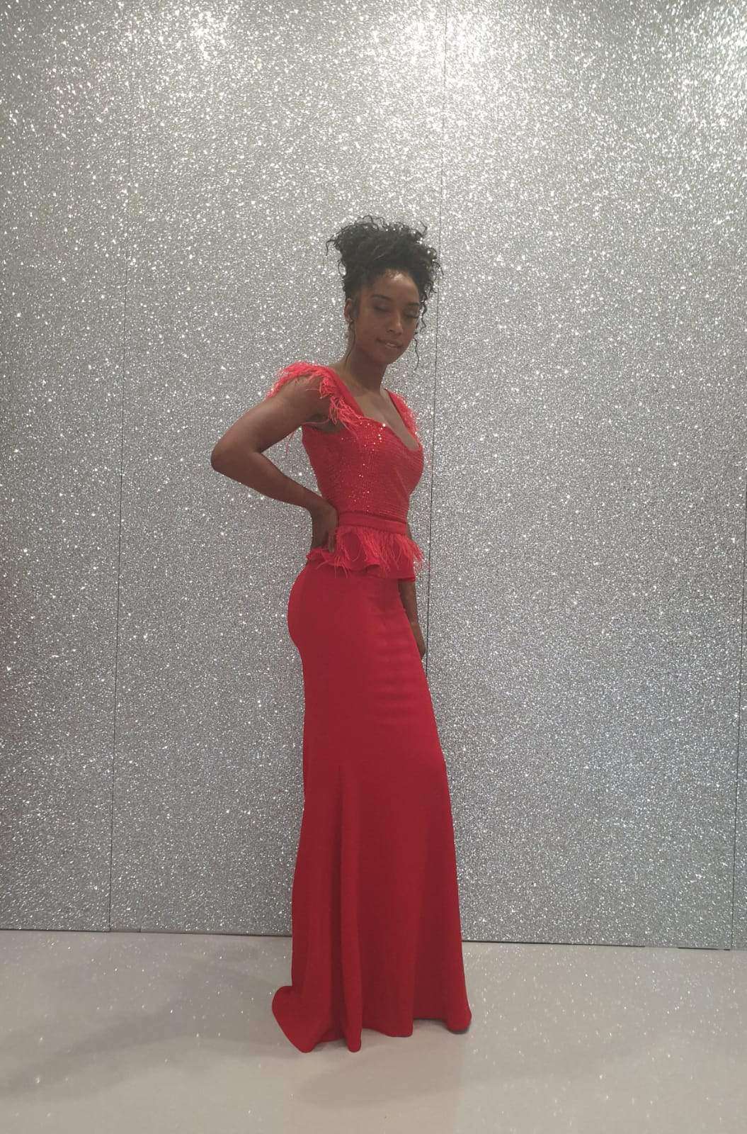 Abito lungo rosso elegante Fofy con corpetto in paillettes, balza in vita e dettagli in piume, ideale per occasioni speciali.