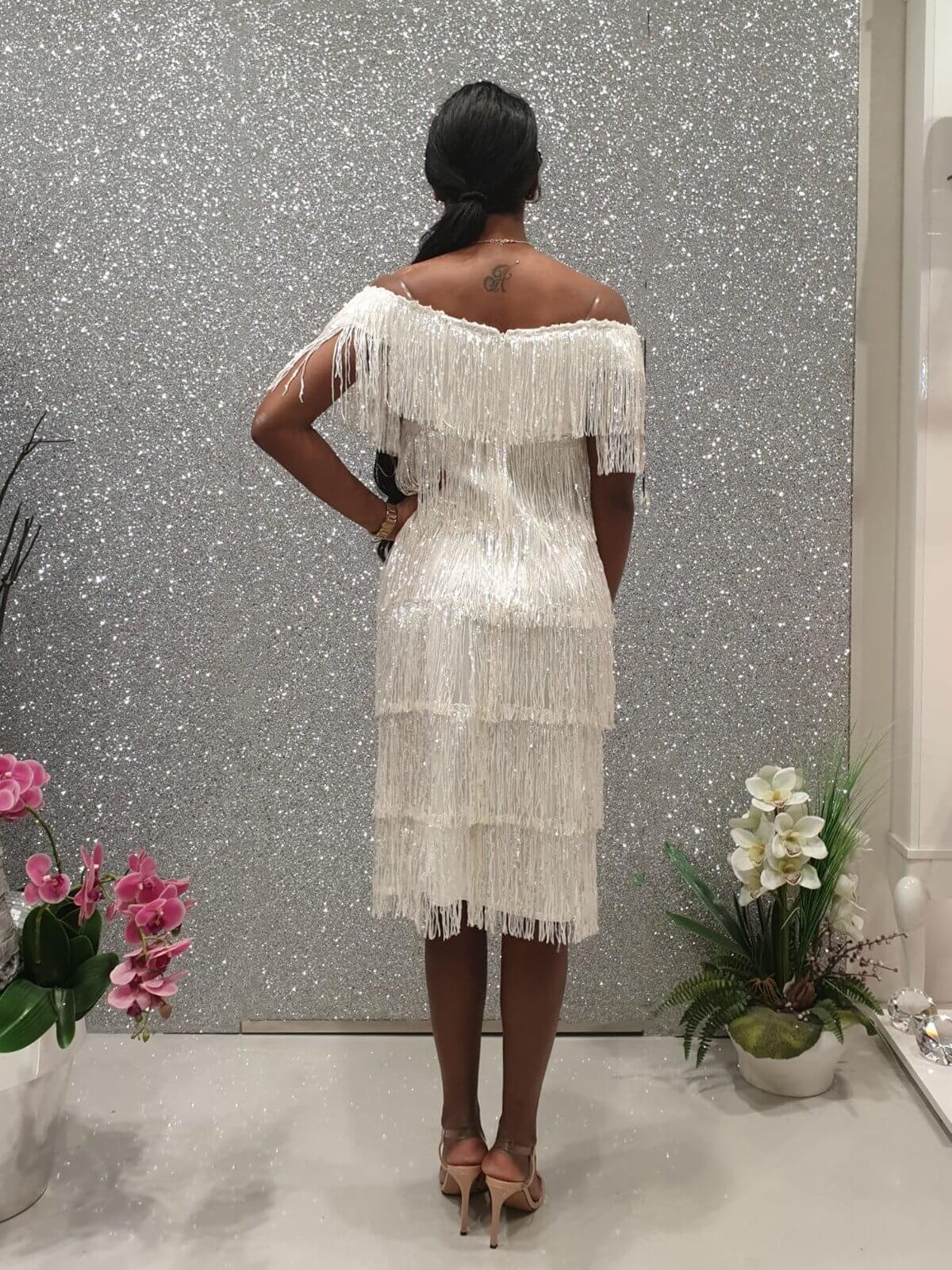 Abito bianco corto Moda Mania con frange decorative in paillettes e scollo a barchetta, maniche tre quarti, elegante e alla moda